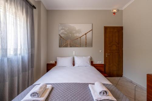 a bedroom with a bed with towels on it at Bay View House in Petalidhion