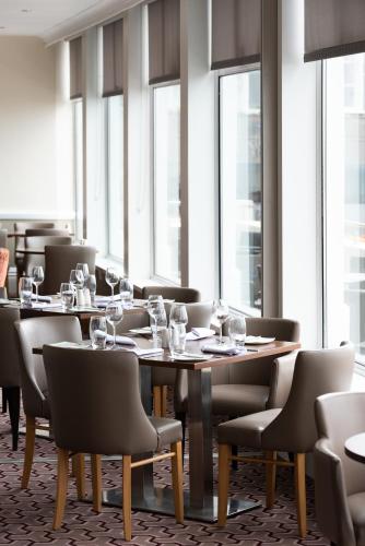 a dining room with tables and chairs and windows at Best Western Carlton Hotel in Blackpool