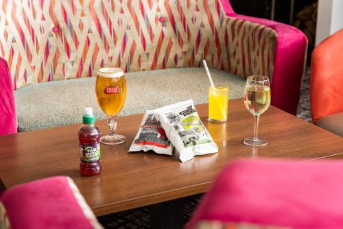 a table with two glasses of beer and a newspaper at Best Western Carlton Hotel in Blackpool