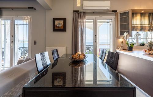 a dining room with a table and a kitchen at Bay View House in Petalidi