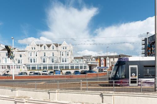 a train on a track in a city with buildings at Best Western Carlton Hotel in Blackpool