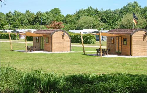 a couple of small wooden cottages in a park at Amazing Home In Ssel With Wifi in Süsel