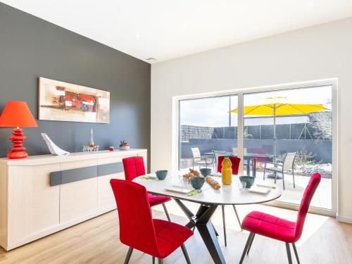 a kitchen and dining room with a table and red chairs at Holiday Home Les Bruyères by Interhome in Tréflez