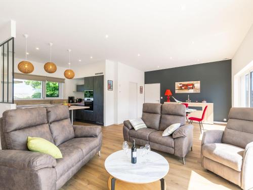 a living room with two couches and a table at Holiday Home Les Bruyères by Interhome in Tréflez