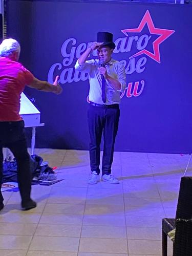 a man in a top hat standing on a stage at Sea Palace Hotel in Marina di Fuscaldo