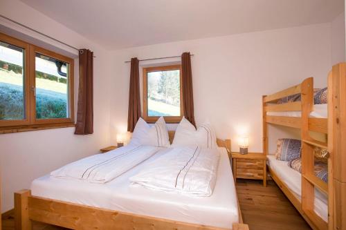 a bedroom with a bed and two bunk beds at Haus Rendl 1 in Bramberg am Wildkogel