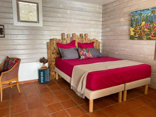 a bedroom with a large bed with a wooden headboard at VILLA DIAMANTILLES - MAISON D'HOTES in Le Diamant