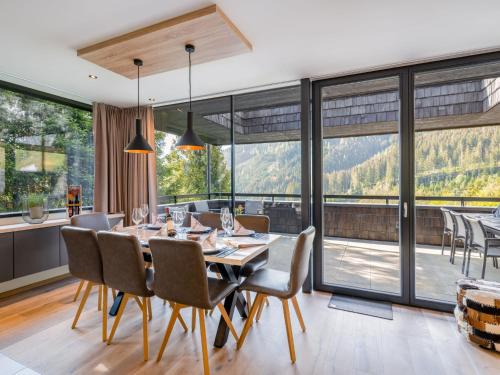 a dining room with a table and chairs and large windows at Apartment Sunny by Interhome in Zell am See