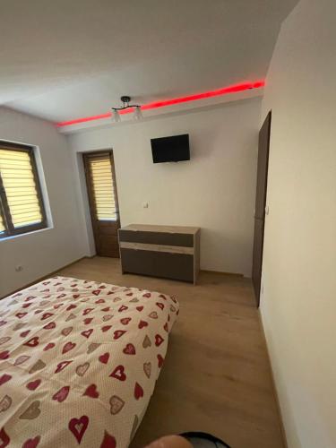 a bedroom with a bed and a flat screen tv at Cabana Retegan Băile Figa in Beclean