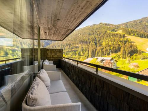balcón con sofás y vistas a la montaña en Apartment Top 2 by Interhome, en Zell am See