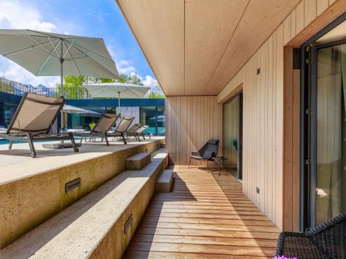 an outdoor deck with chairs and an umbrella at Apartment Emma Deluxe Aparthotel-2 by Interhome in Fürth