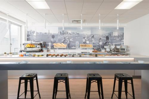 a kitchen with three stools in front of a counter at Hotel Imperiale in Cattolica