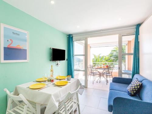 un salon avec une table et un canapé bleu dans l'établissement Studio L'Esquinade P1 101 by Interhome, à Agay