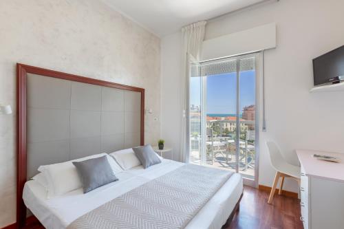 a bedroom with a large bed with a large window at Hotel Imperiale in Cattolica