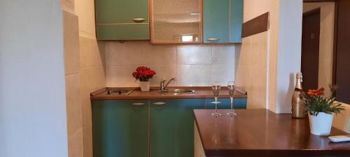 a kitchen with a sink and a counter with wine glasses at Ambassador Apartments in Petrovac na Moru