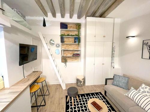 een woonkamer met een bank en een trap bij Loft Augustins in Parijs