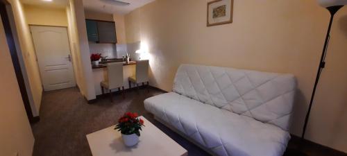 a living room with a white couch and a table at Ambassador Apartments in Petrovac na Moru