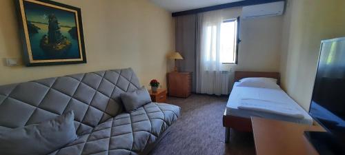 a hotel room with a couch and a bed at Ambassador Apartments in Petrovac na Moru