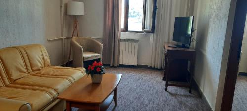 a living room with a couch and a tv at Ambassador Apartments in Petrovac na Moru