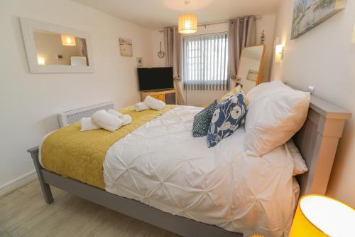 a bedroom with a large bed with pillows on it at Driftwood in Marazion