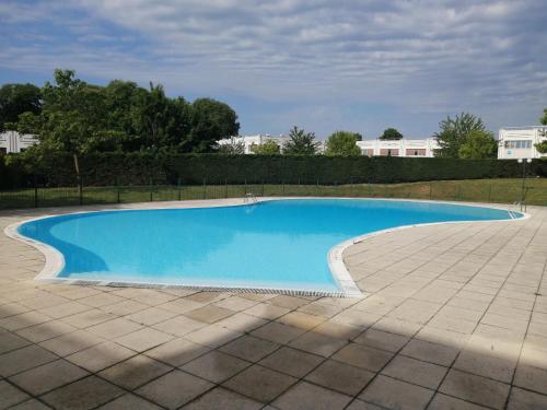 a large blue swimming pool with a tile patio at Romantisme et glamour avec spa, piscine et jardin in Dijon
