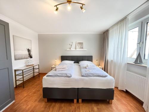 a bedroom with a large bed and a window at M5 Bungalow - Apartmenthaus Marienburger Str 4 - FERIENDOMIZIL HOLLICH in Grömitz