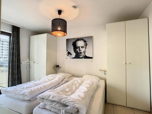 twee bedden in een kamer met een foto aan de muur bij Appartement 'Plaza' te Oostduinkerke - Bad in Oostduinkerke-Bad