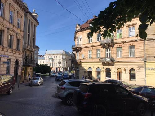 une rue de la ville avec des voitures garées dans la rue dans l'établissement Apartments on Shevchenko avenue, à Lviv