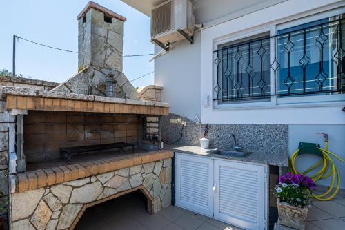 an outdoor kitchen with a stone oven and a sink at Bay View House in Petalidi