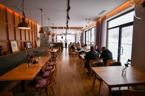 a restaurant with people sitting at tables in a room at Hotel Kulla e Bajraktarit in Bogë