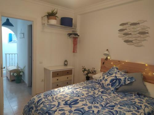 a bedroom with a bed with a blue and white comforter at La Motilla in Barbate