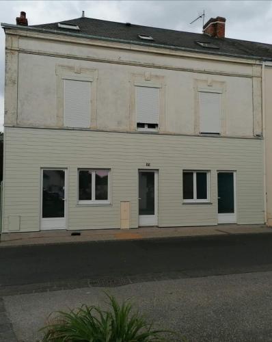 a large white building with windows on a street at Charmant F2 in Noyant