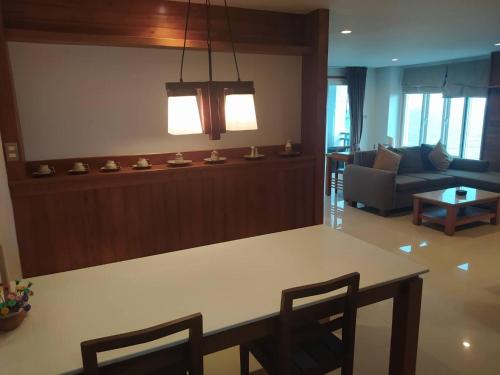 sala de estar con mesa y sofá en Khanom Beach Residence 1-Bedroom Ocean Front Condo en Khanom