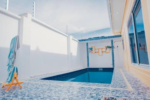 a swimming pool in a house with blue tiles on the floor at Heavenly ApHEARTment with backyard swimming pool in Dodoma