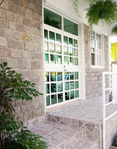 a front door of a home with glass doors at La Flamboyant Hotel in Roseau