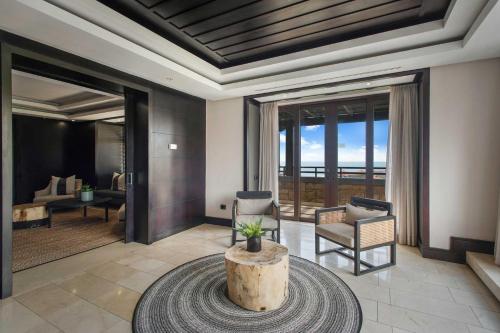 a living room with a table and chairs and glass doors at The Capital Zimbali in Ballito
