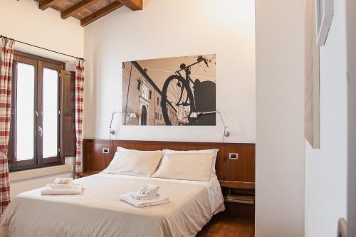 ein Schlafzimmer mit einem Bett mit einem Fahrrad an der Wand in der Unterkunft Boutique Rooms 3 0 in Ferrara