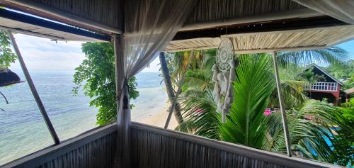 a balcony with a view of a beach and the ocean at Hotel ECOLODGE LE RAVORAHA in Sainte Marie