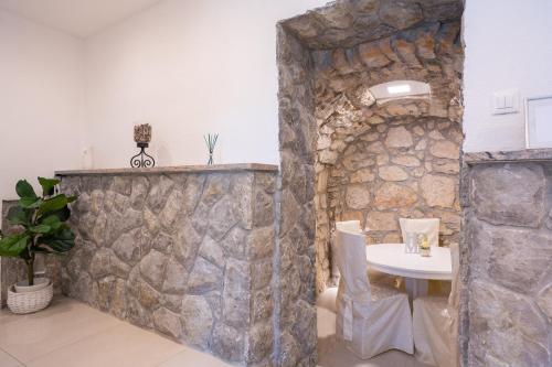 een stenen muur in een kamer met een tafel bij Apartment Tina in Vrh