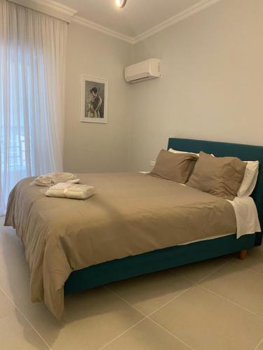 um quarto com uma cama com uma moldura azul e uma janela em Modern Living in Markopoulo center em Markopoulo Mesogaias
