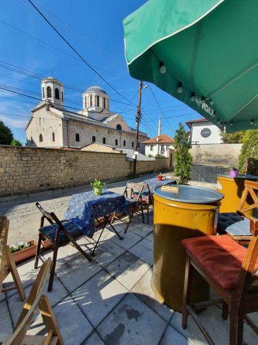 un patio con sillas, una mesa y una sombrilla en Guesthouse Hotel My Home, en Prizren
