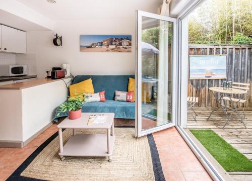 une cuisine et un salon avec un canapé et une table dans l'établissement Les Canonniers, à Lège-Cap-Ferret