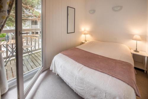a bedroom with a bed and a balcony at Les Canonniers in Lège-Cap-Ferret