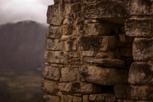 a stone wall with a view of a mountain in the background at Hotel Fundo Achamaqui in Chachapoyas