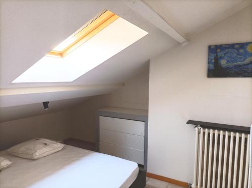 Cette chambre comprend un lit et une lucarne. dans l'établissement Au calme à Avignon, à Avignon