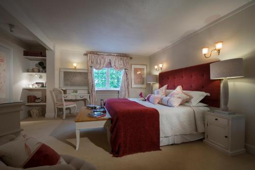 a bedroom with a large bed with a red headboard at The Old Mill in Lymington