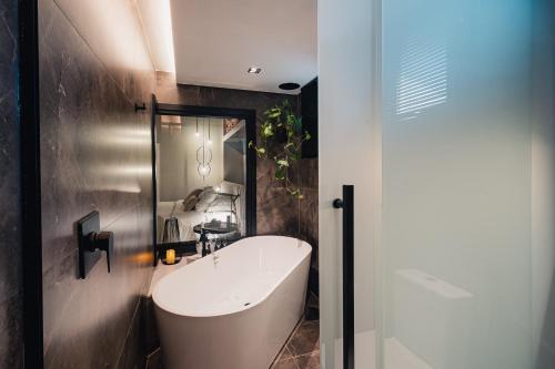 a bathroom with a white tub and a sink at Pousada Bella Terra in Gramado