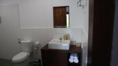 biała łazienka z umywalką i toaletą w obiekcie Tree Tops Mandalika w Kuta Lombok