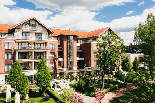 an apartment building with a courtyard with trees at Willa Port Apartament Premium z widokiem na jezioro in Ostróda