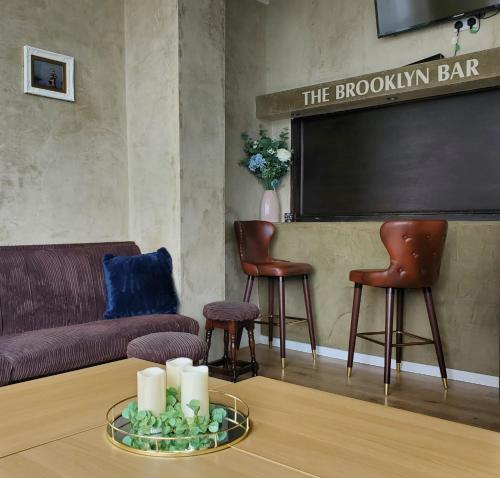 a living room with a couch and chairs and a chalkboard at Brooklyn Hotel in Blackpool